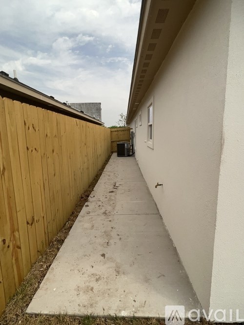 A long concrete pathway leads to a building.