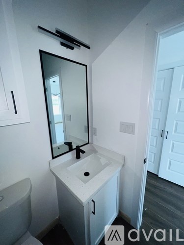 A bathroom with a sink, mirror and toilet.