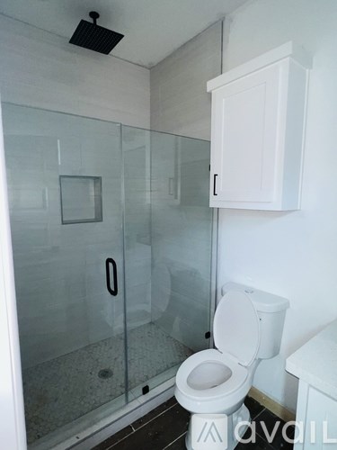 A white toilet in a bathroom with a glass shower door.