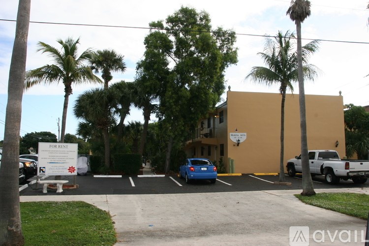 A building with a "For Rent" sign in front of it.