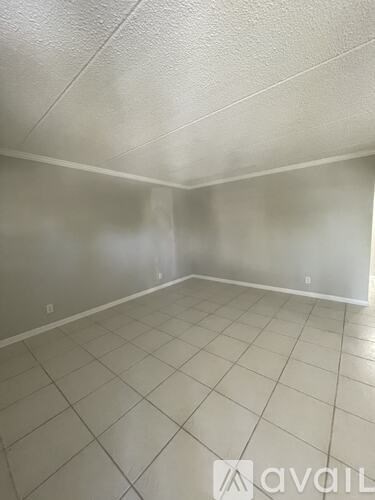 A room with white tiled flooring and a white ceiling.