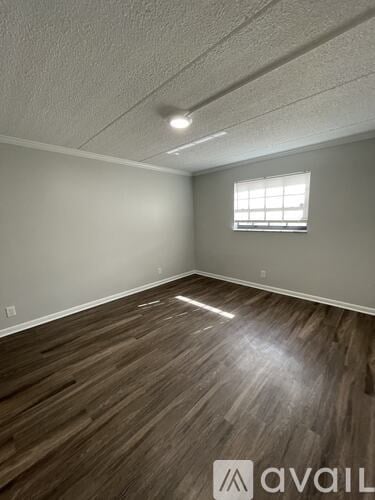 A room with wooden flooring and a window.
