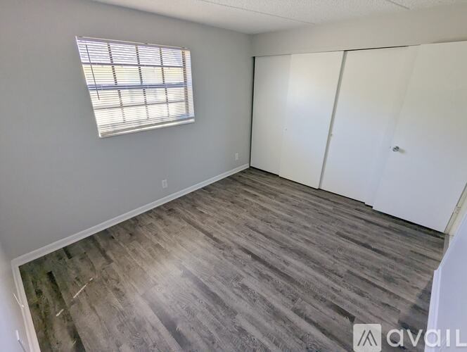 A room with a window and wooden flooring is available for rent.