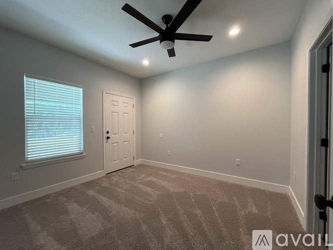 A room with a ceiling fan and carpeted floor.