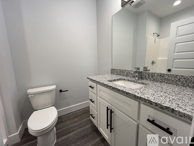 A bathroom with a toilet, sink, and mirror.