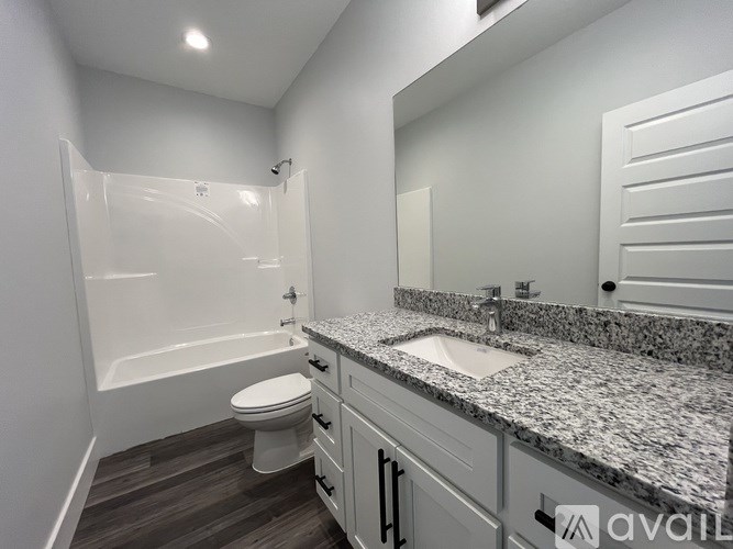 A bathroom with a granite countertop and a white toilet.