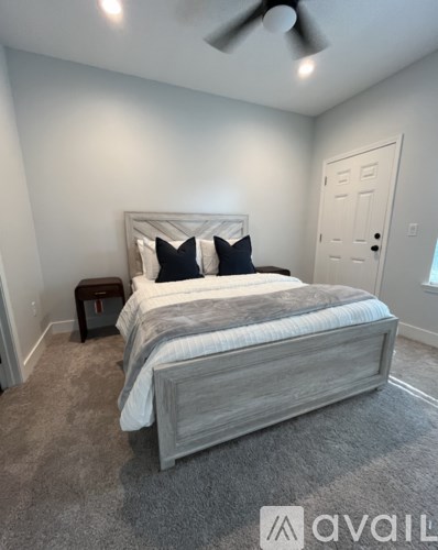 A bedroom with a large bed and a ceiling fan.