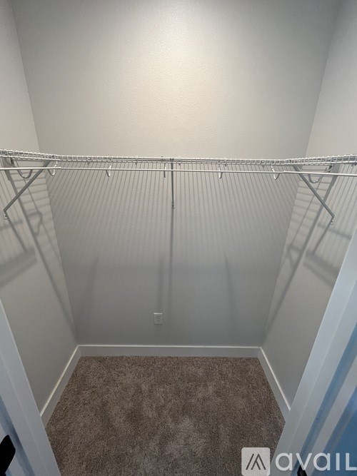 A small, empty room with a carpeted floor and a metal rack.