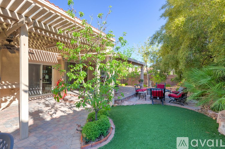 A patio with a table and chairs under a pergola.