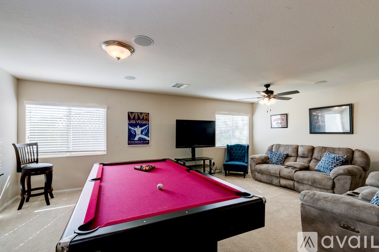 A pool table is in the middle of a living room.