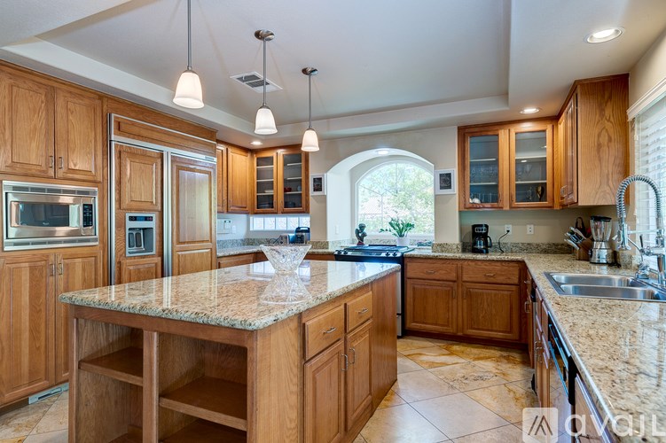 A kitchen with wooden cabinets and granite countertops.