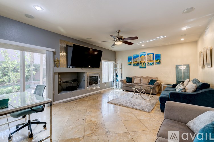 A living room with a television, couches, and a rug.