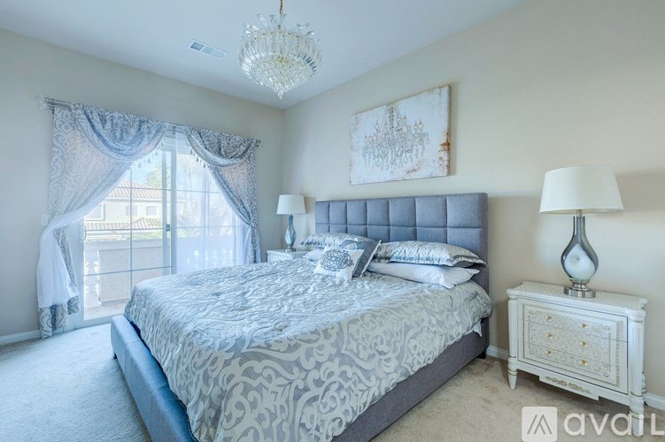 A bedroom with a large bed and a chandelier.