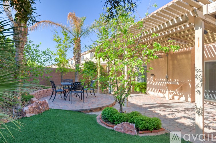 A patio with a table and chairs under a pergola.
