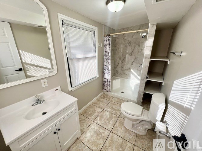 A bathroom with a sink, toilet, and shower.