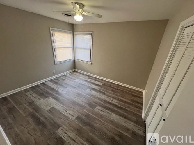 A room with wooden flooring and a ceiling fan.