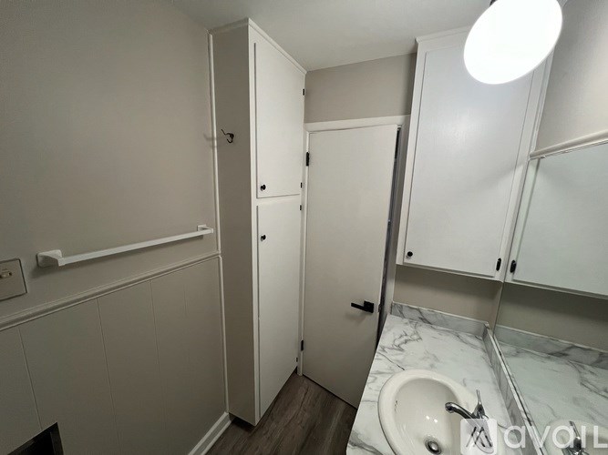 A white bathroom with a sink and a mirror.