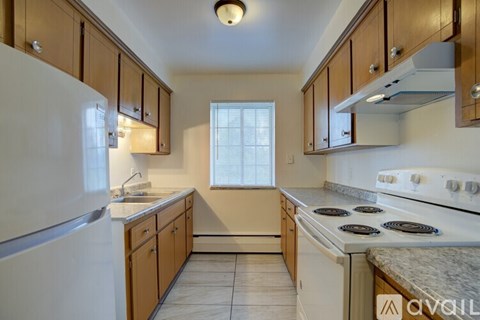 A kitchen with white appliances and wooden cabinets.