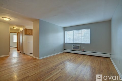 A spacious room with wooden floors and a window.