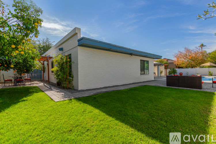 A modern house with a white exterior and a blue roof is for sale.