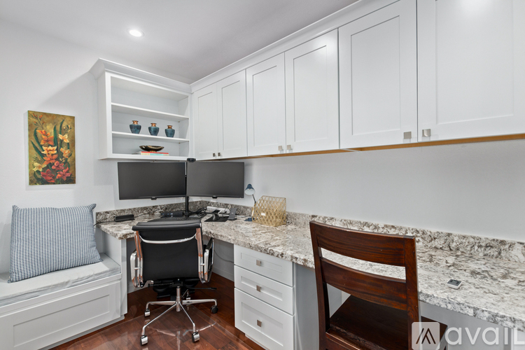 A kitchen with a desk and a chair.