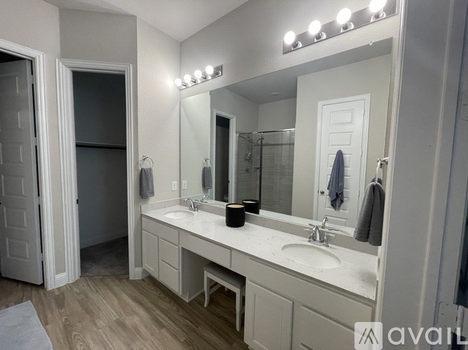 A bathroom with a vanity, mirror, and lights.