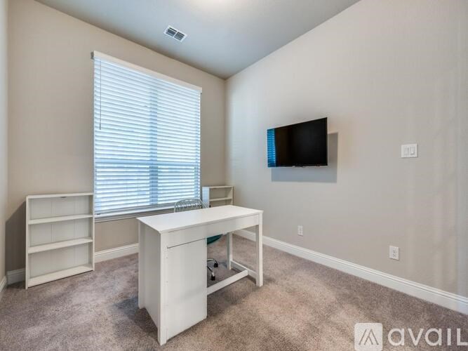 A glass shower stall with a white floor and a drain in the center.