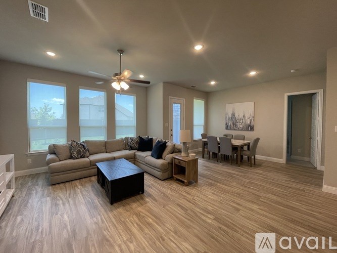 A spacious living room with a large sectional sofa, a coffee table, and a dining area with a table and chairs.