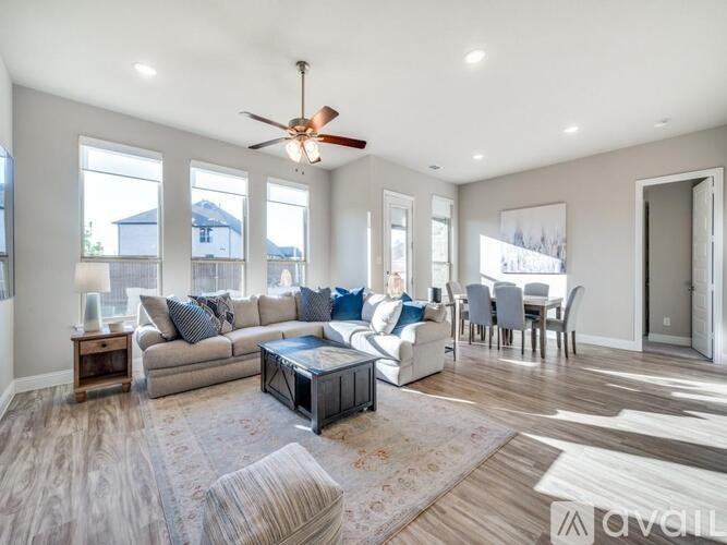 A dining room with a table and chairs and a painting on the wall.