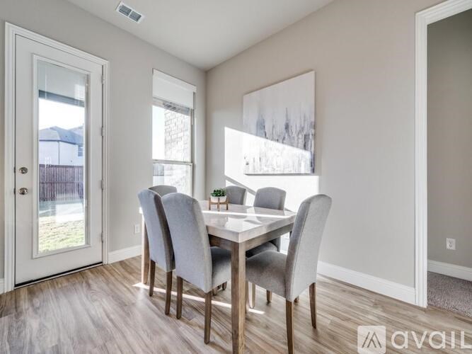 A bed with a grey headboard and a blue and white striped comforter.