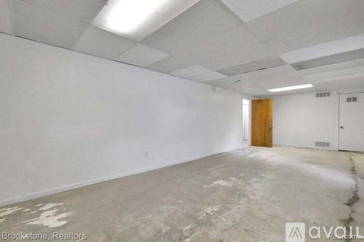 A large empty room with a door and a window.