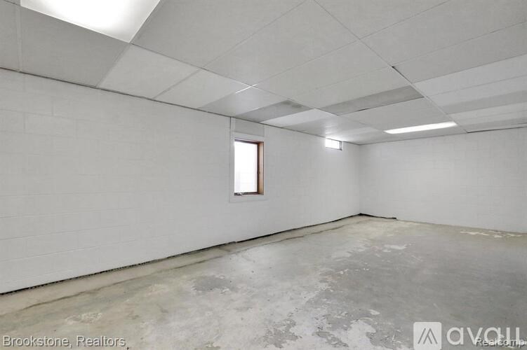 A spacious room with a window and a concrete floor.