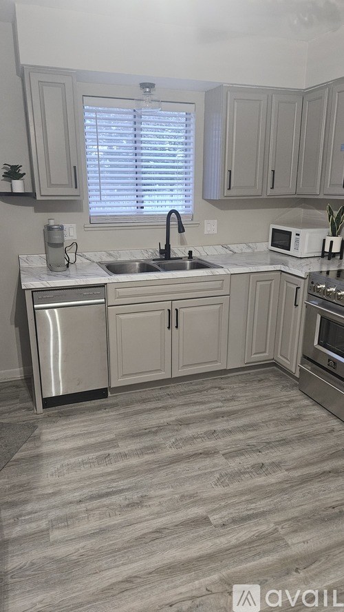 A kitchen with a sink, dishwasher, and oven.