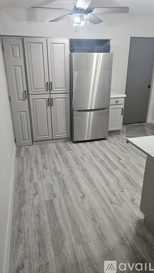 A kitchen with a refrigerator and cabinets.