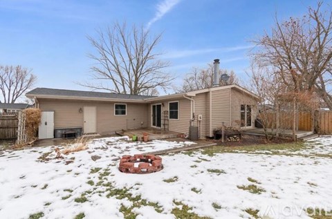 A house with a snow-covered ground in front.