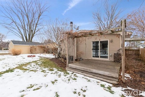A house with a deck in the snow.