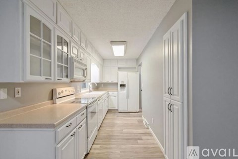 A kitchen with white appliances and cabinets.
