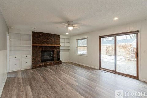 A spacious living room with a fireplace and sliding glass doors.