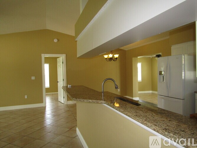 A bathroom with a yellow wall and a granite countertop.