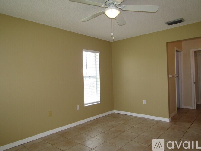 A room with a ceiling fan and a window.