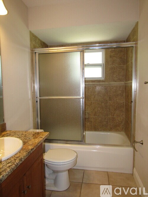 A bathroom with a toilet, sink, and shower.
