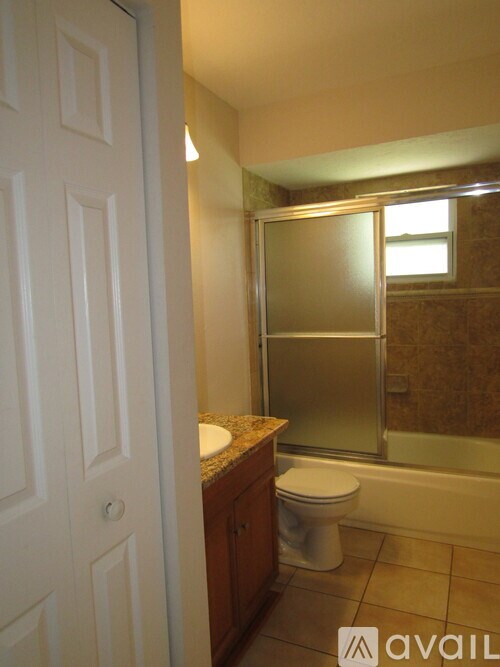 A bathroom with a toilet, sink, and shower.
