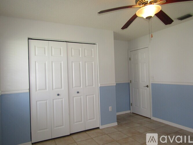 A room with a ceiling fan and two doors.