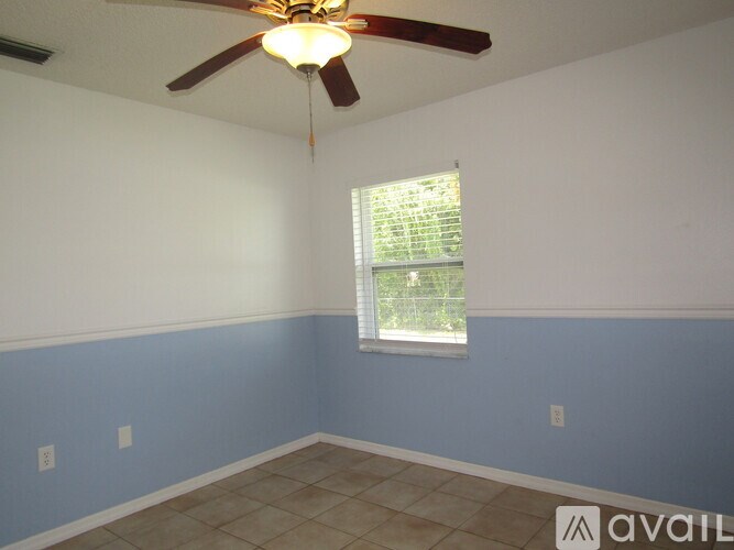 A room with a ceiling fan and a window with blinds.