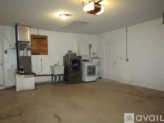 A room with a washing machine and a refrigerator.