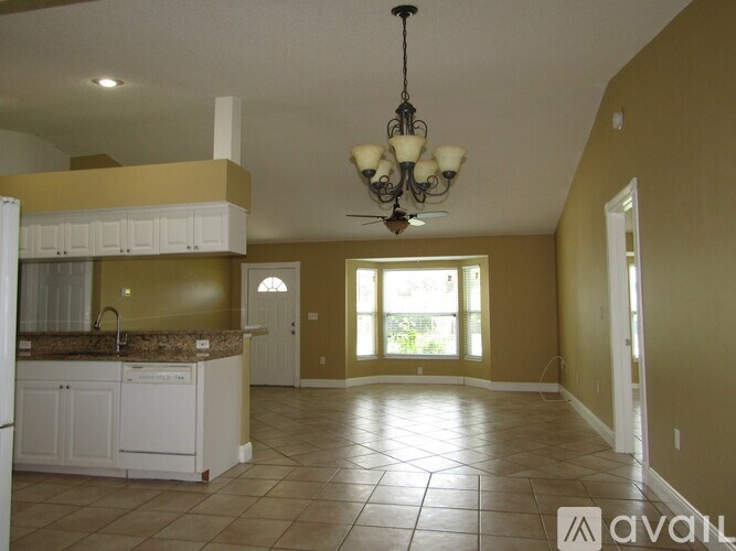 A kitchen with white cabinets and a granite countertop.