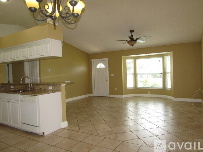 A kitchen with yellow walls and a white cabinet.