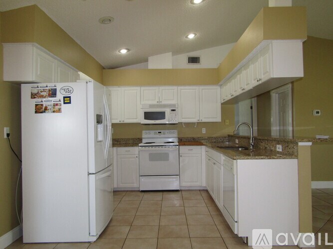 A kitchen with white appliances and cabinets.