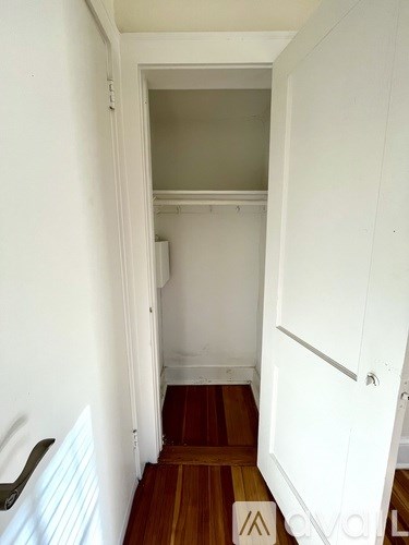 A hallway with a white door and a wooden floor.