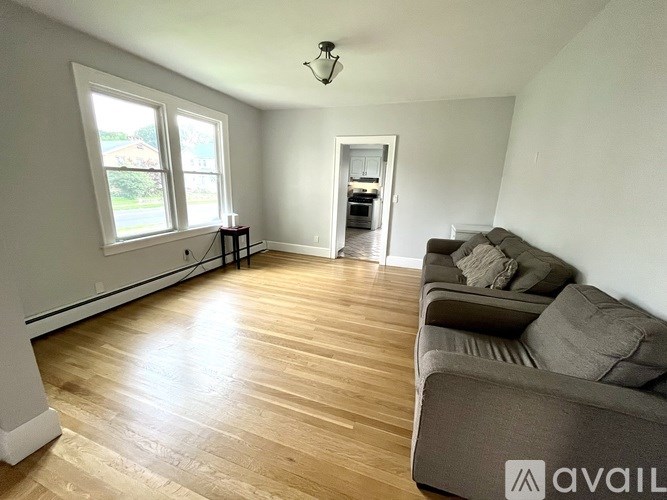 A living room with a couch and a window.